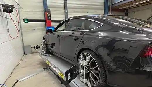 Auto nelipyöräsuuntauksessa Automaalaamo H. Haapojan hallissa.